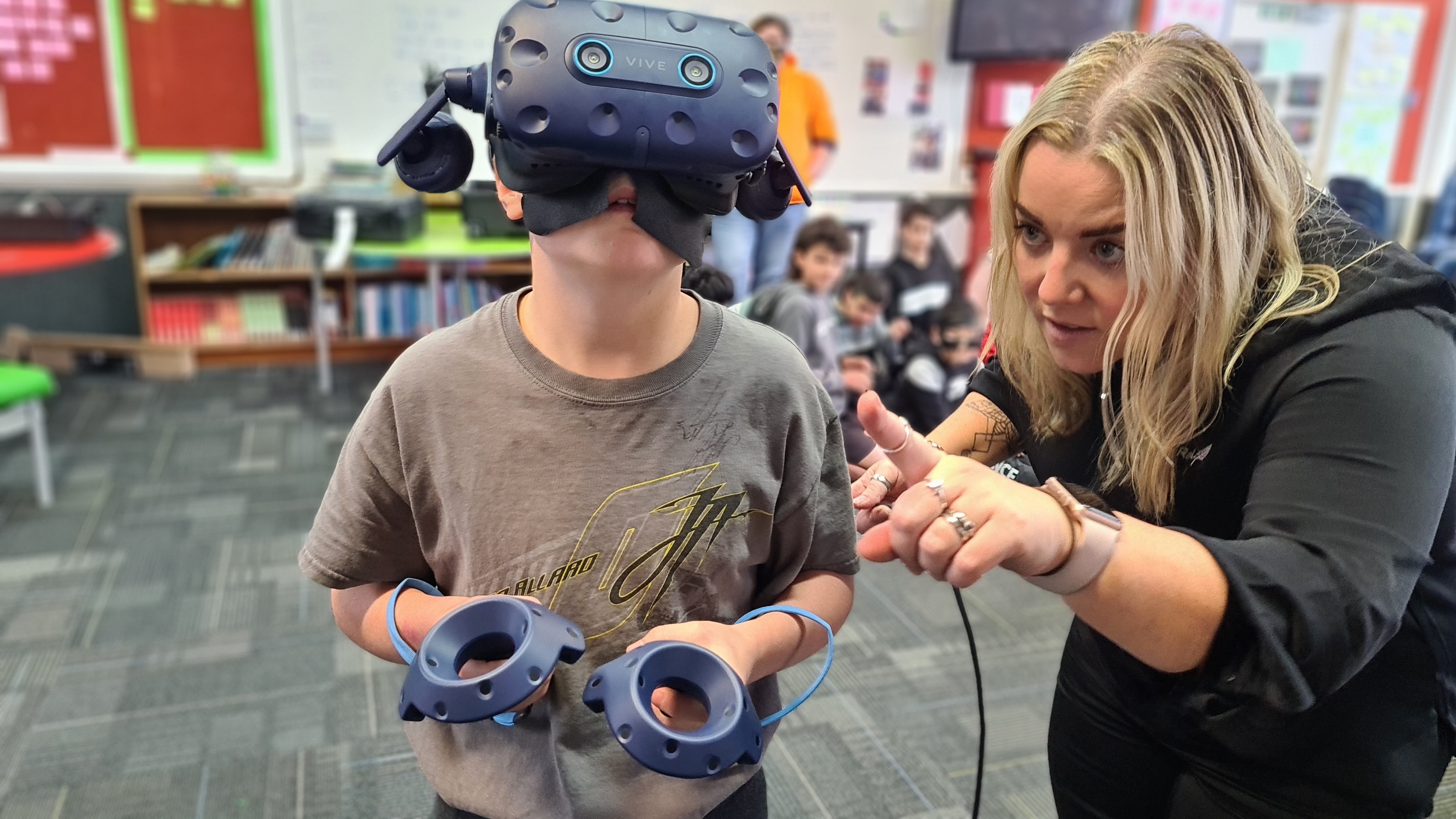 Student tries virtual reality with help from KiwiRail staff member.
