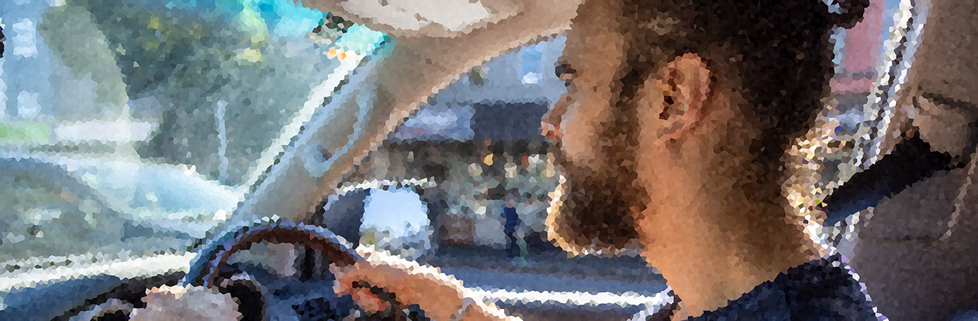 Pixelated image of person driving a car.